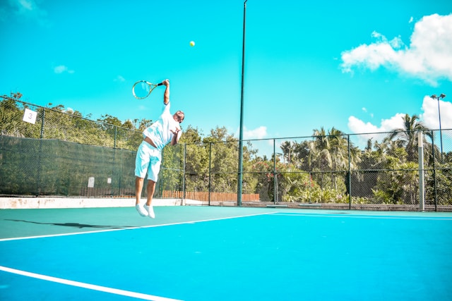 Tennis instructor providing personalized coaching to student, demonstrating the importance of lessons in skill development