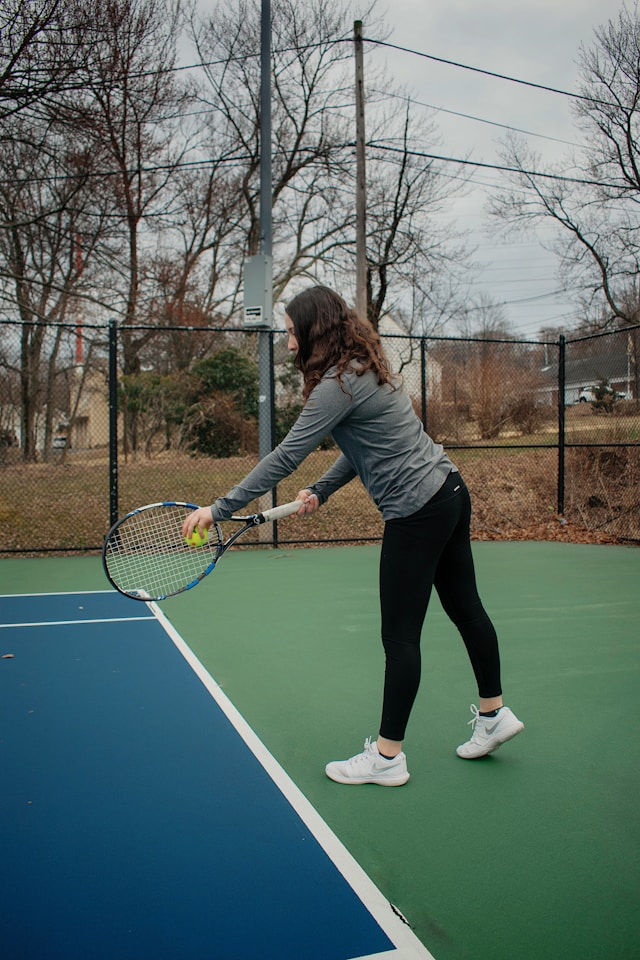 Tennis player practicing technique with focused determination, showing the dedication required for skill improvement